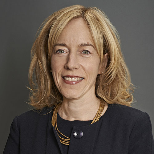Head shot of a woman in a black shirt in front of a dark gray background