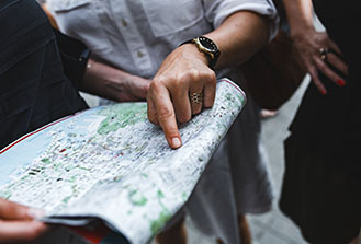 Local Chapter Man's hand pointing to location on a paper map that a second person is holding
