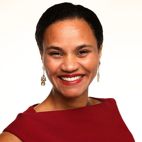 Headshot of a woman in a red dress with her hair pulled back and gold dangling earrings