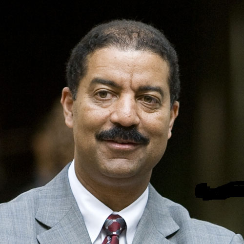 Close up of a man in a gray suit and maroon tie
