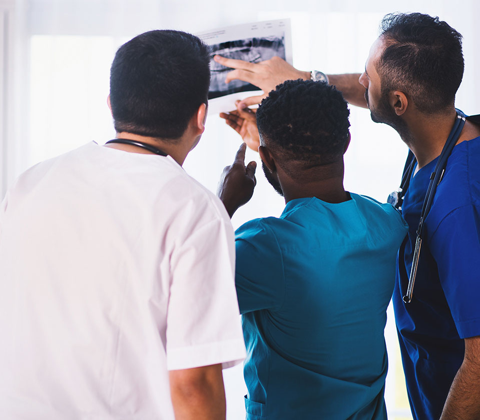 Three male medical professionals looking at an X-ray