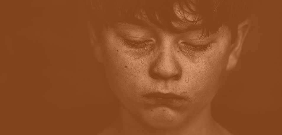 Young book looks down sadly while tears roll down his face