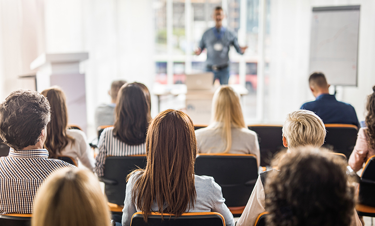 Back view of a group of business people having a training class in a board room.